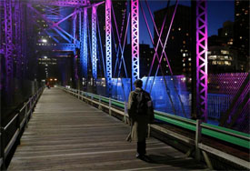 View of the northern avenue bridge in Boston illuminated by purple lights at night